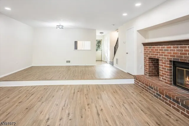 an empty room with wooden floor and fireplace