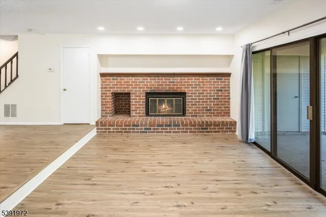 an empty room with wooden floor and fireplace