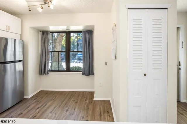 a view of hallway with wooden floor and a window