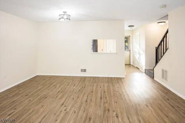 a view of a room with wooden floor and a hallway