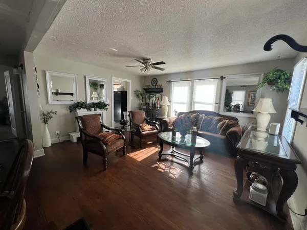 a living room with furniture a large window and wooden floor
