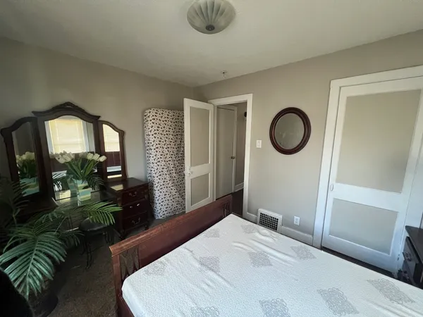 a bedroom with bed and a potted plant
