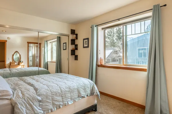 a bedroom with a bed a dresser and painting on the wall