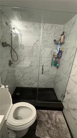 a bathroom with a toilet sink shower and mirror