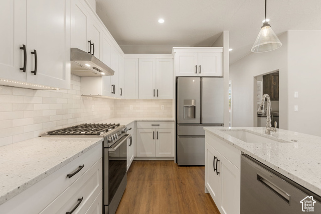 1192 East Ashdown Road Cedar City, UT 84721 - Photo 51 of 96 White shaker cabinetry with black hardware, stainless steel appliances, speckled countertops, white subway tile backsplash, and wood-finish flooring
