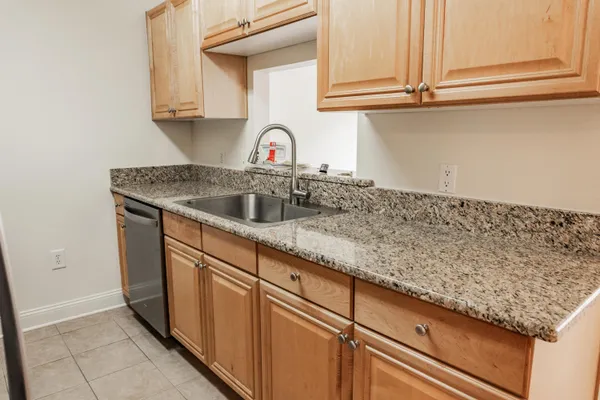 a kitchen with granite countertop a sink and cabinets