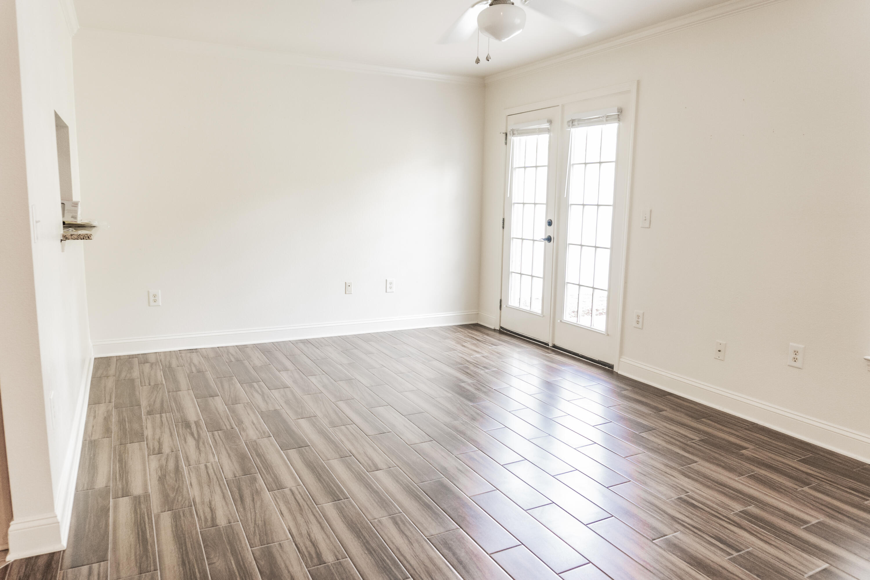 560 Wingspan Way Crestview, FL 32536 - Photo 5 of 18 an empty room with wooden floor and windows