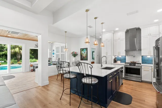 a view of a dining room and livingroom with furniture wooden floor a chandelier