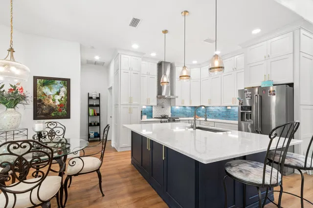 a kitchen with stainless steel appliances a dining table chairs and couches