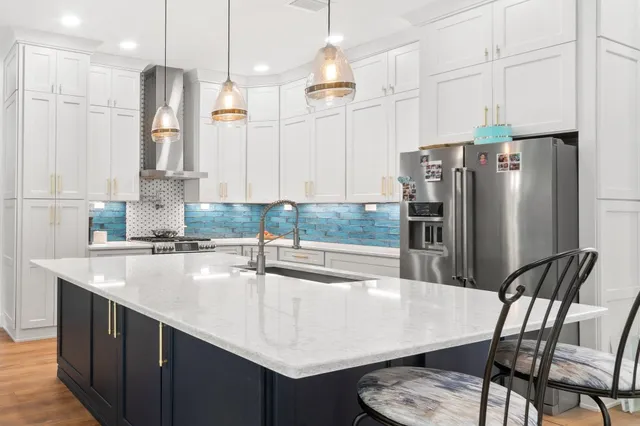 a kitchen with stainless steel appliances granite countertop a sink refrigerator and cabinets