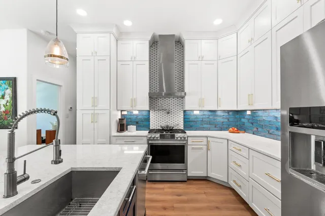 a kitchen with stainless steel appliances granite countertop a stove a sink and a refrigerator