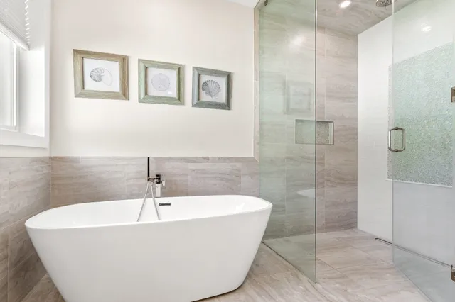 a white bath tub sitting in a bathroom and shower