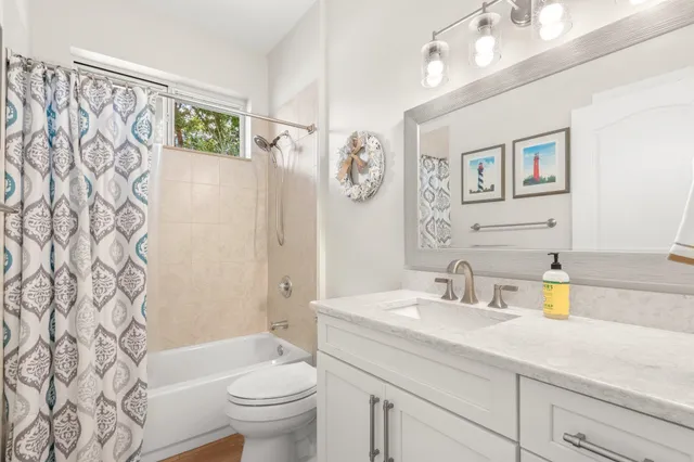 a bathroom with a sink a toilet and shower curtain
