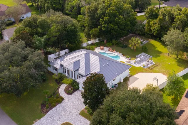 an aerial view of a house with a yard and lake view
