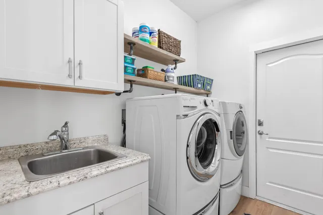 a utility room with sink dryer and washer