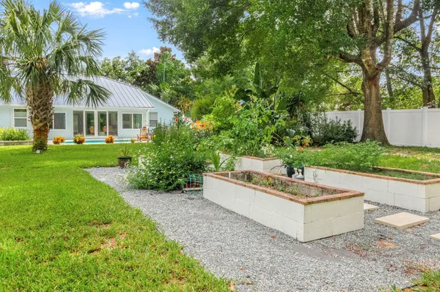 a view of a house with a yard and large trees