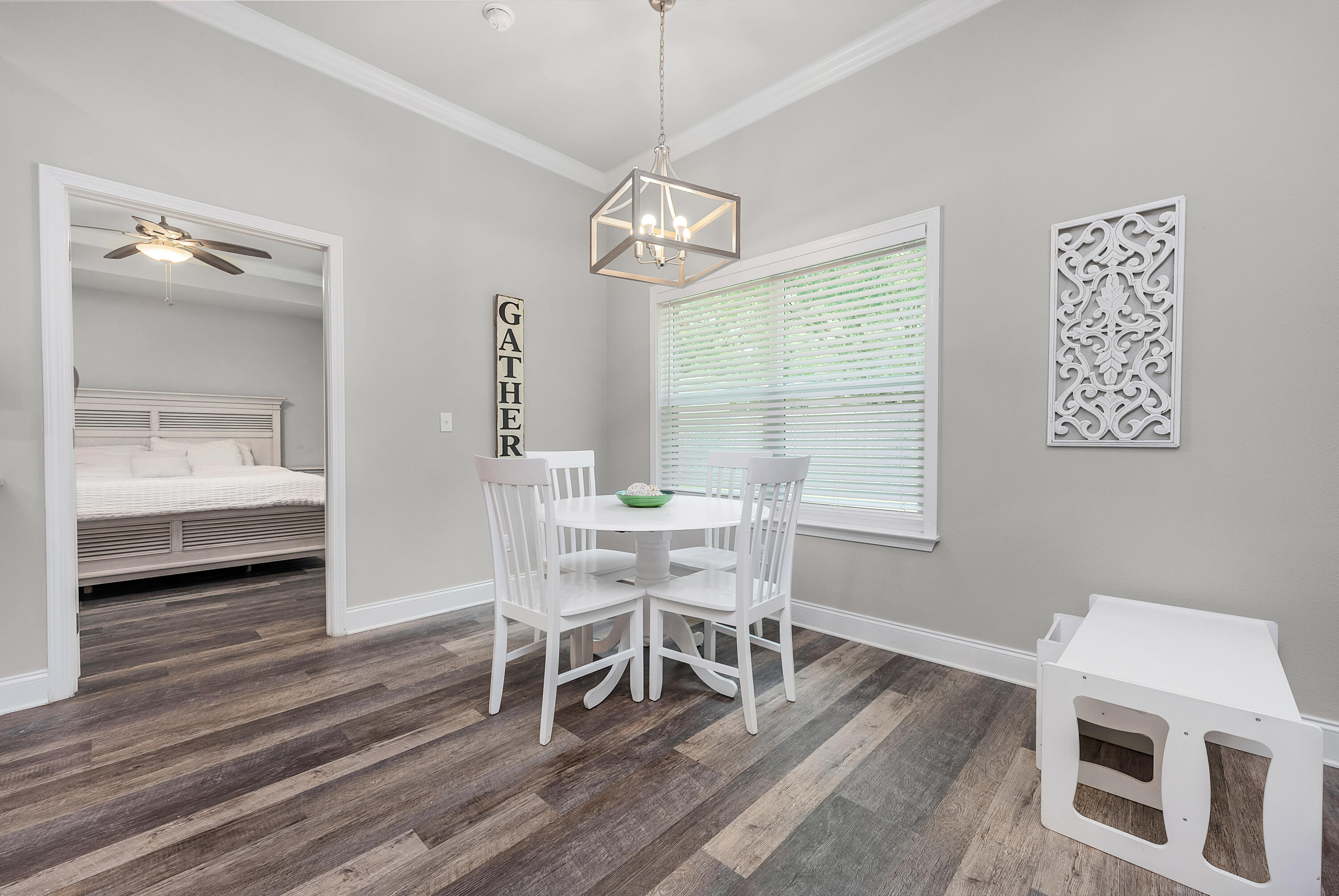 820 Hilltop Road Mary Esther, FL 32569 - Photo 28 of 47 a dining room with wooden floor a chandelier a wooden table and chairs