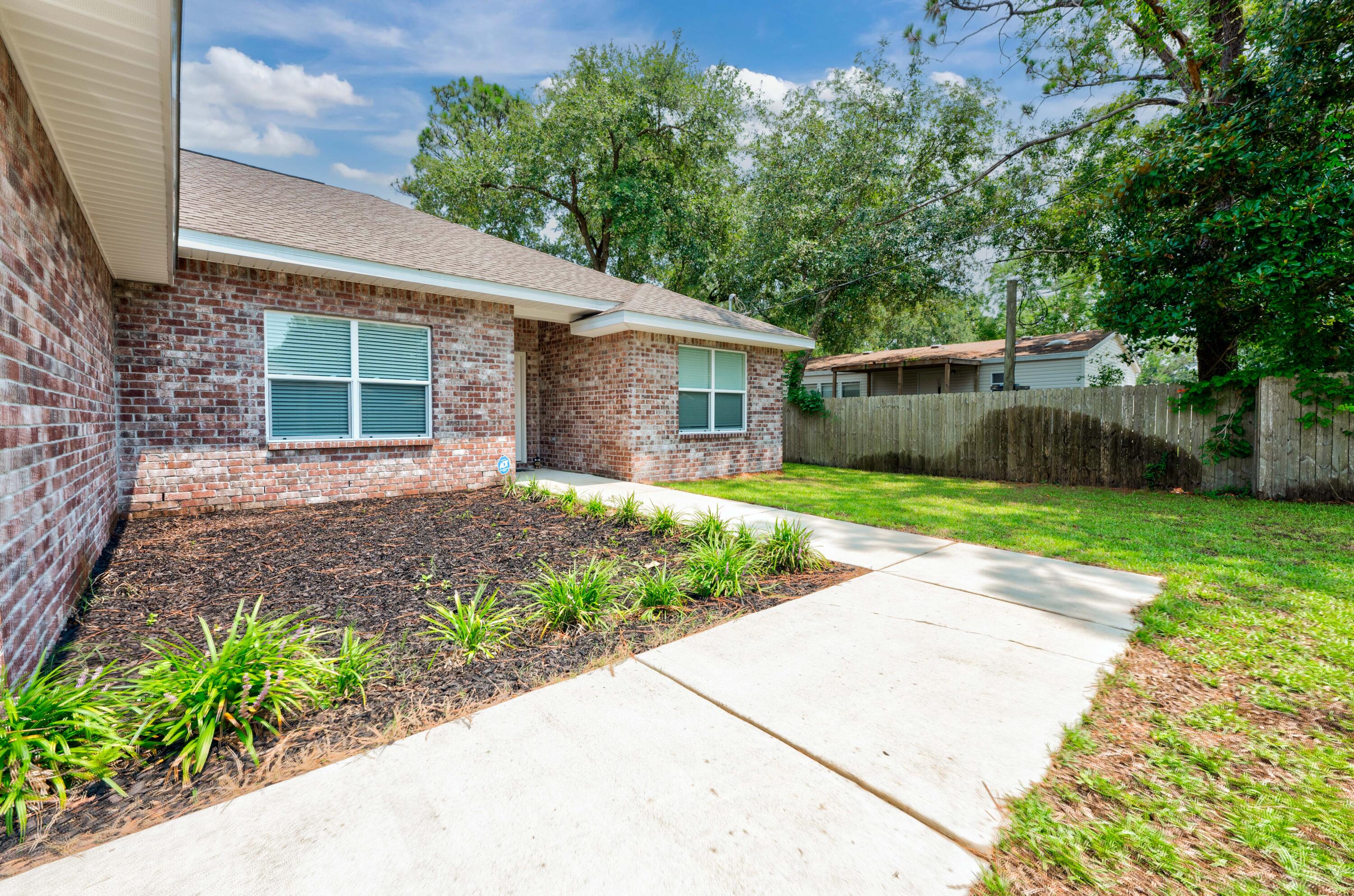 820 Hilltop Road Mary Esther, FL 32569 - Photo 4 of 47 a front view of a house with garden