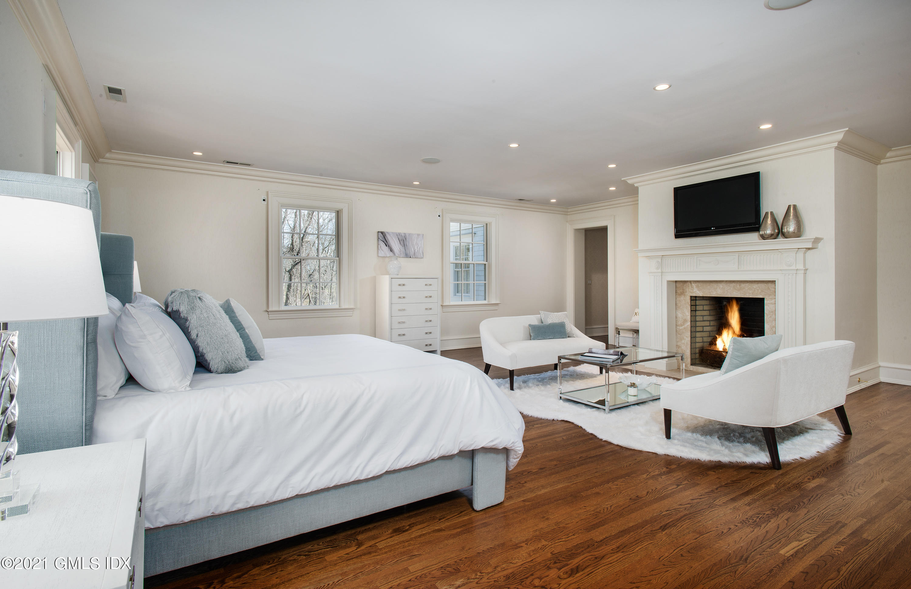 65 Clapboard Ridge Road Greenwich, CT 06830 - Photo 22 of 36 a bedroom with a bed and a fireplace