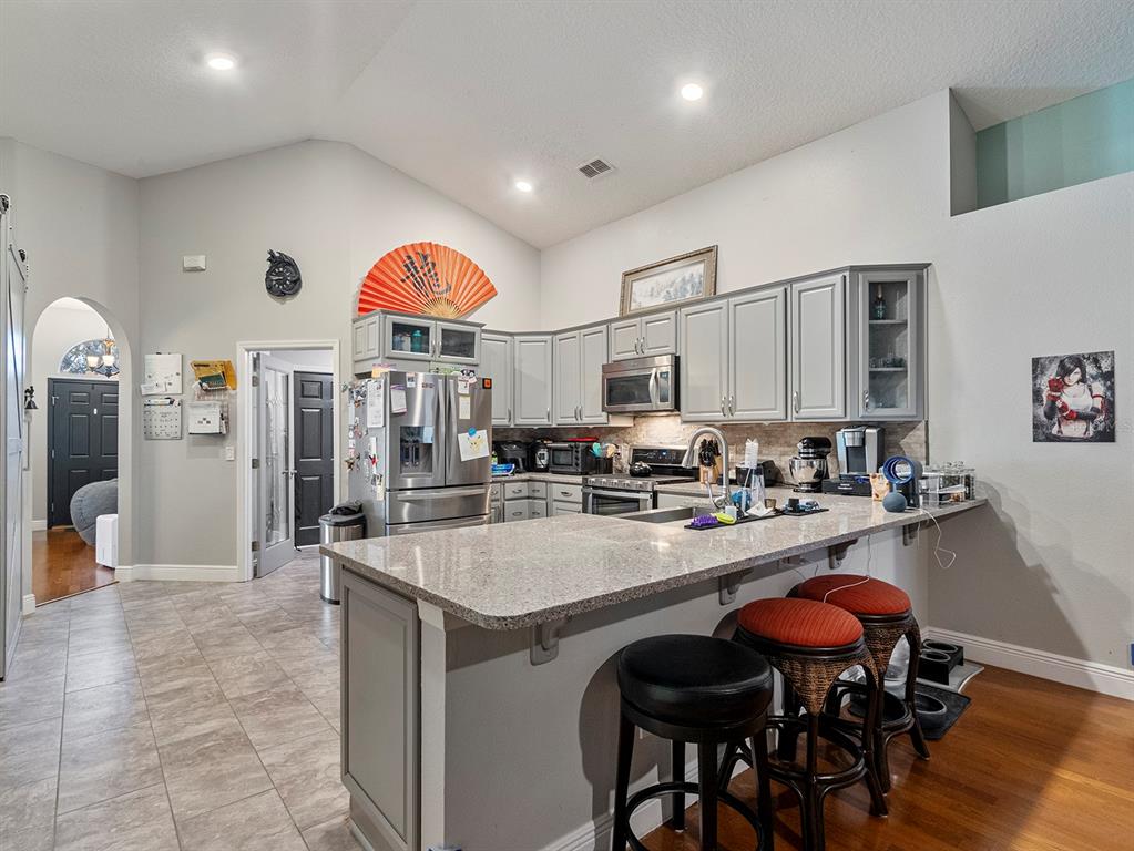 549 Placid Run Road Orange City, FL 32763 - Photo 11 of 20 a kitchen with stainless steel appliances granite countertop a stove refrigerator and cabinets