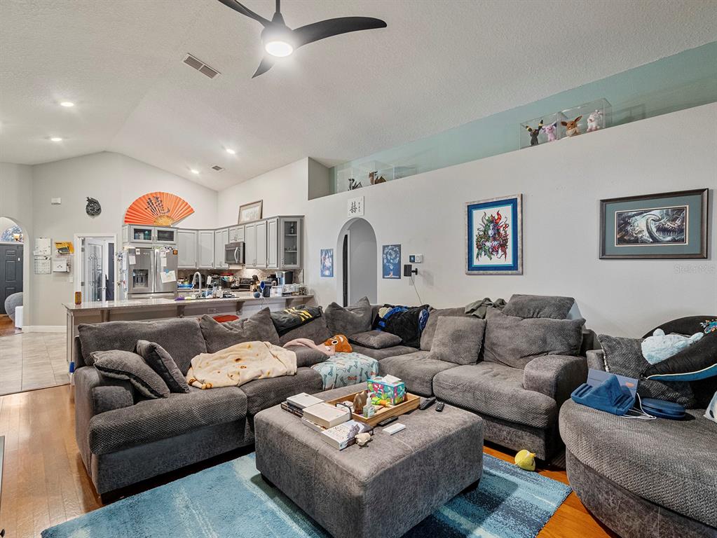 549 Placid Run Road Orange City, FL 32763 - Photo 13 of 20 a living room with furniture kitchen view and a chandelier