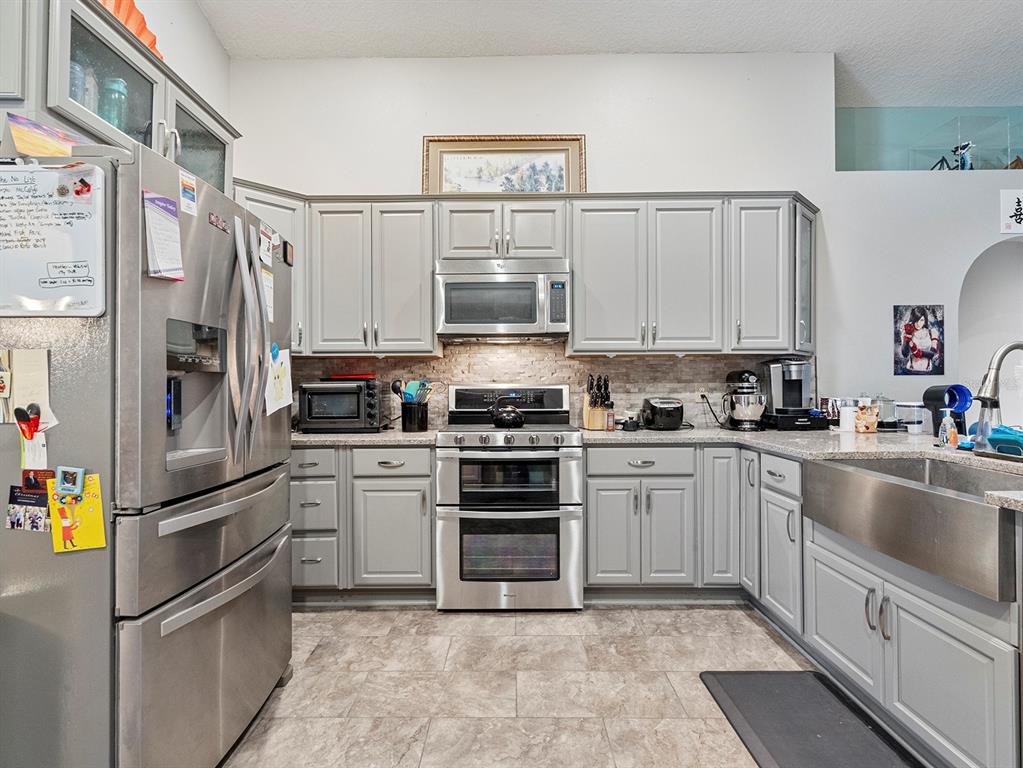 549 Placid Run Road Orange City, FL 32763 - Photo 5 of 20 a kitchen with stainless steel appliances granite countertop a refrigerator and a sink