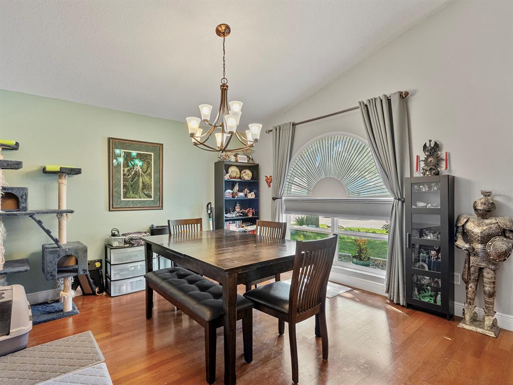 549 Placid Run Road Orange City, FL 32763 - Photo 9 of 20 a dining room with furniture a chandelier and wooden floor