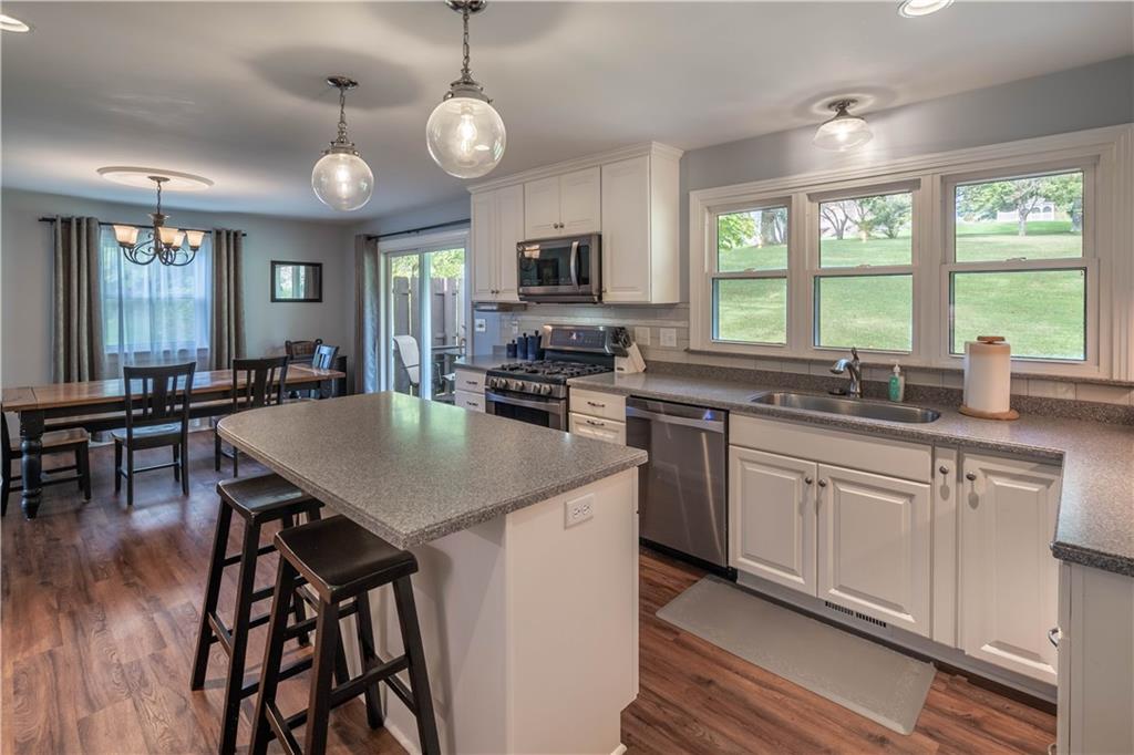 445 Springdale Road Eighty Four, PA 15330 - Photo 3 of 20 a kitchen with stainless steel appliances granite countertop a stove a sink a microwave a dining table and chairs