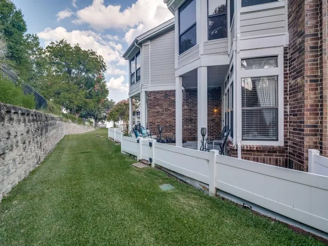 a view of a house with a yard and a large tree