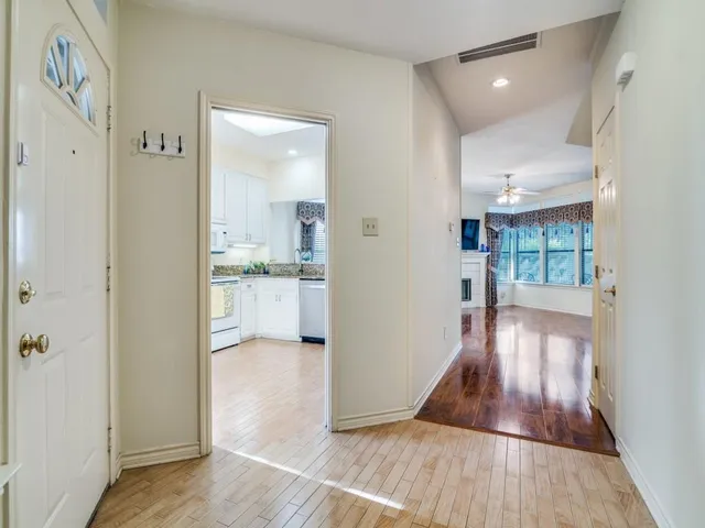 a view of a hallway view with wooden floor and a living room