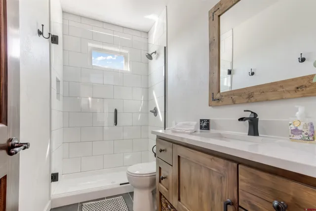 a bathroom with a sink a toilet and shower