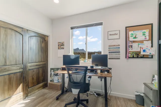 a view of a workspace with furniture and a window