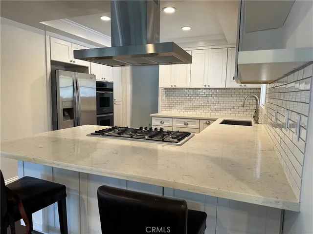 a kitchen with stainless steel appliances a sink a stove and a refrigerator