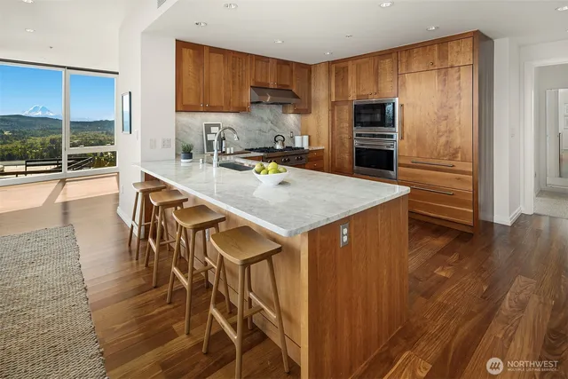 a kitchen with kitchen island a counter top space a sink refrigerator and cabinets