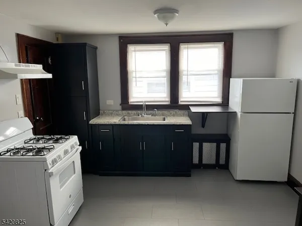 a kitchen with a stove a refrigerator and a sink