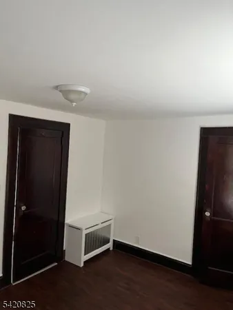 an empty room with wooden floor and closet