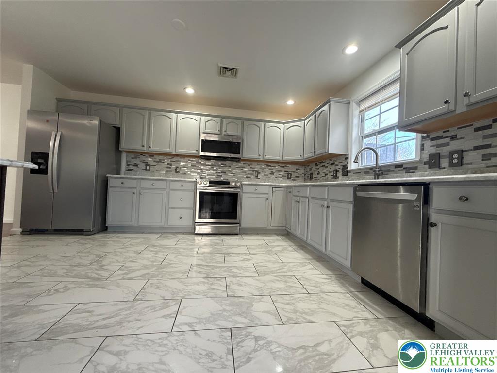4141 Walter Road Bethlehem, PA 18020 - Photo 4 of 34 a kitchen with stainless steel appliances granite countertop a stove top oven a sink a stove a refrigerator and cabinets