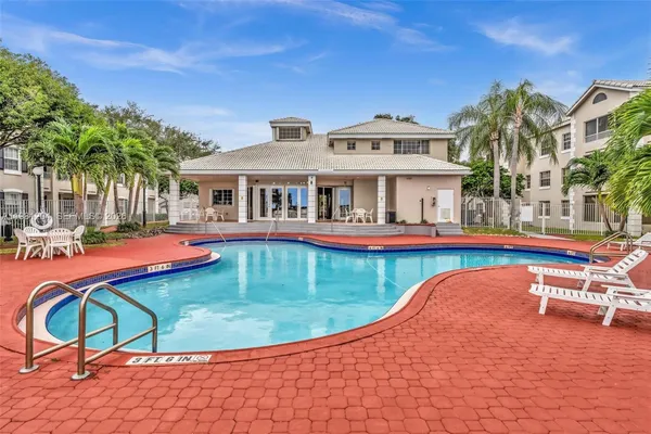 a view of a swimming pool with a lounge chairs in patio