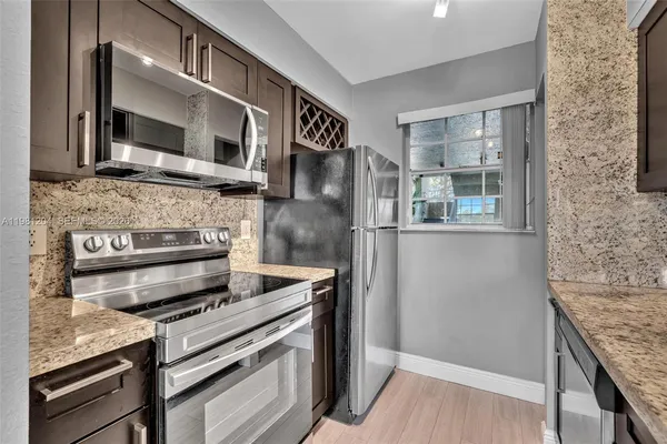 a kitchen with stainless steel appliances granite countertop a stove and a microwave