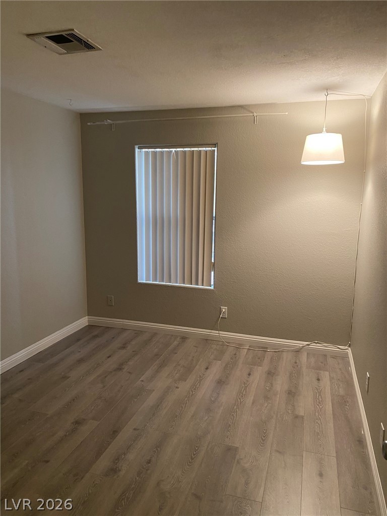 5271 South Lindell Road, Unit 202 Las Vegas, NV 89118 - Photo 18 of 27 Well-lit room featuring durable wood-like flooring and a window with blinds for privacy.