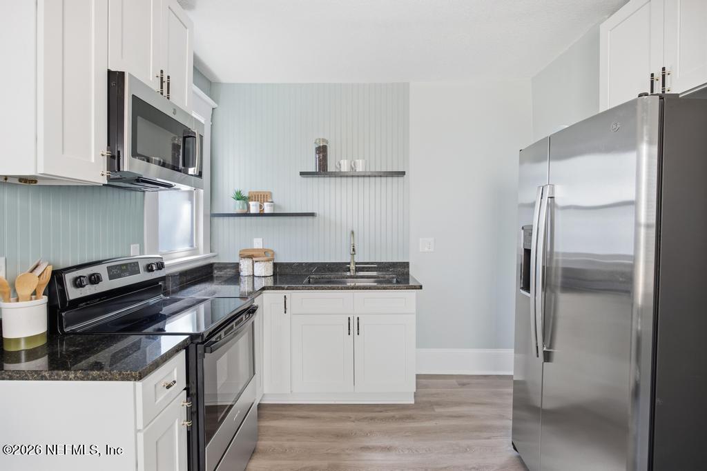 1825 Perry Street Jacksonville, FL 32206 - Photo 36 of 80 a kitchen with stainless steel appliances granite countertop a stove a refrigerator and a microwave