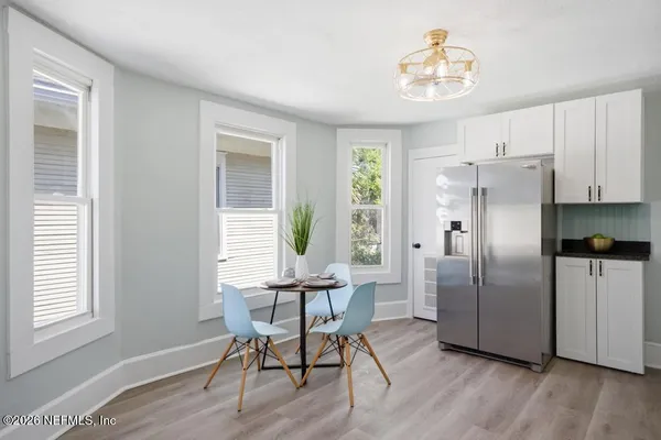 a kitchen with stainless steel appliances granite countertop a stove top oven a sink a refrigerator and white cabinets