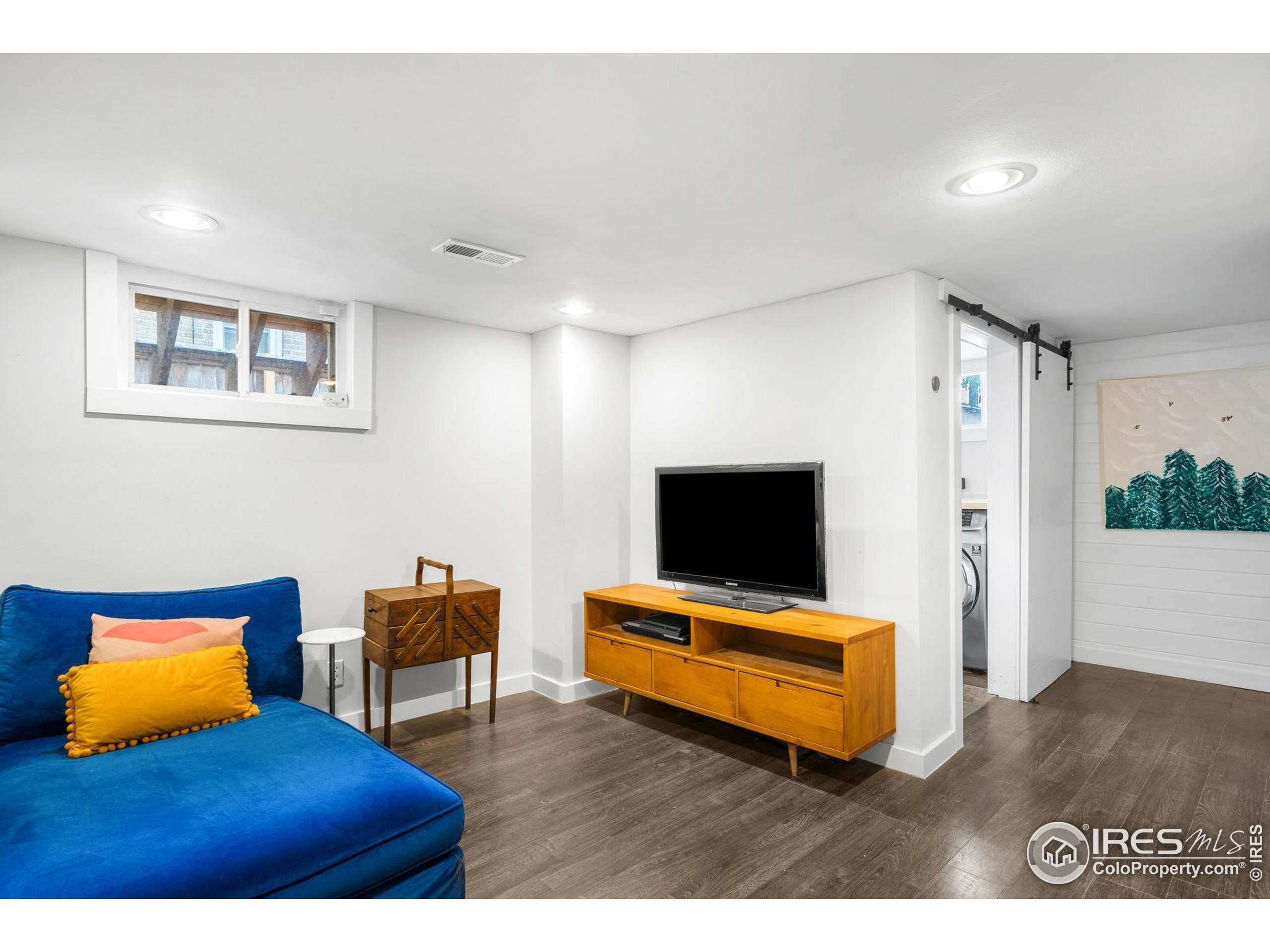3359 Steele Street Denver, CO 80205 - Photo 23 of 48 a living room with furniture and a flat screen tv