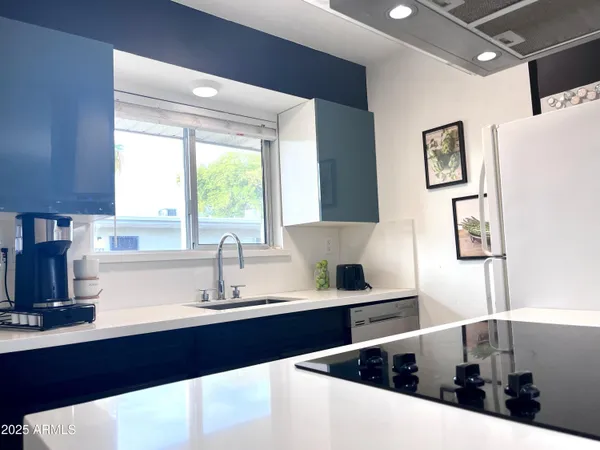a kitchen with granite countertop a sink a counter top space and stainless steel appliances