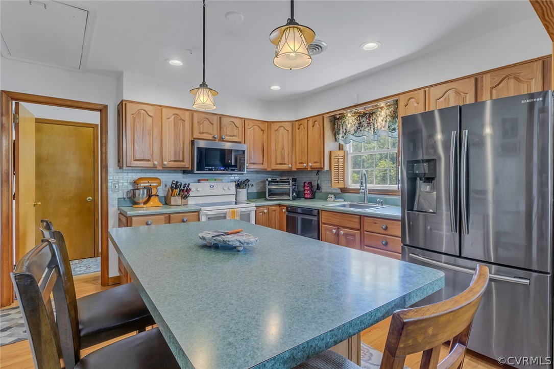 31 Bunker Hill Road Farnham, VA 22460 - Photo 19 of 47 a kitchen with stainless steel appliances granite countertop a stove refrigerator a sink dishwasher a dining table and chairs with wooden floor