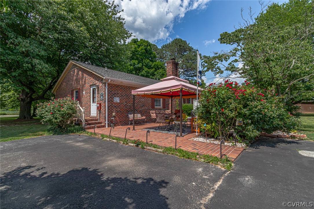 31 Bunker Hill Road Farnham, VA 22460 - Photo 3 of 47 a patio with a table and chairs under an umbrella