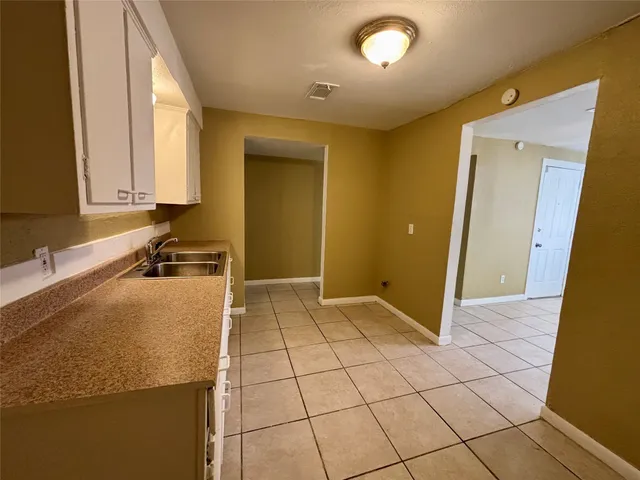 a view of an empty room with a chandelier fan