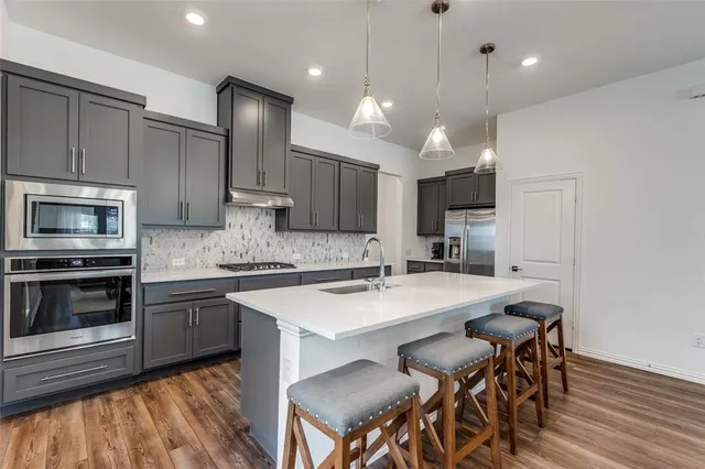 a kitchen with a sink stainless steel appliances and cabinets