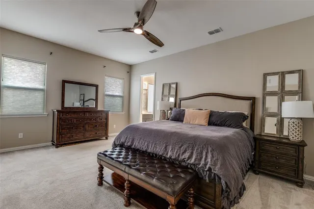 a bedroom with a bed a dresser and a night stand