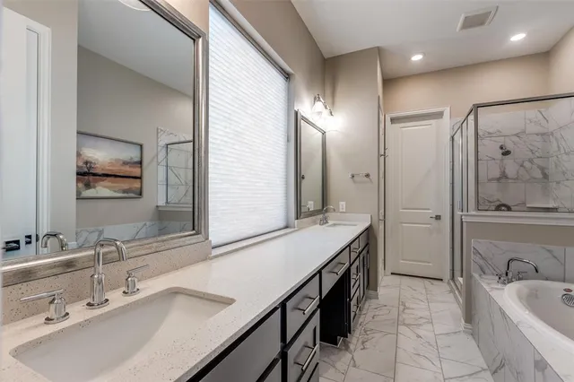 a bathroom with a tub sink and mirror
